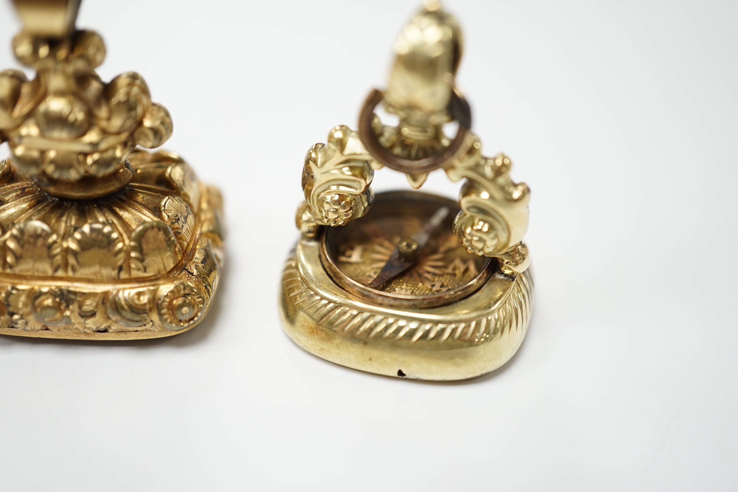 Two 19th century yellow metal overlaid fob seals, the largest 32mm with inset citrine carved with ornate crest and inscribed 'Joy of Life', the other with inset carnelian craved with bee and inscribed 'Non Sibi'.